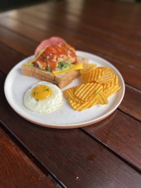 Tahta masada yumurta ve pastırmalı sandviç.