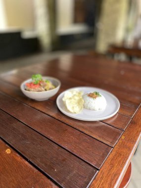 Tahta masada beyaz bir tabakta kızarmış pirinç.