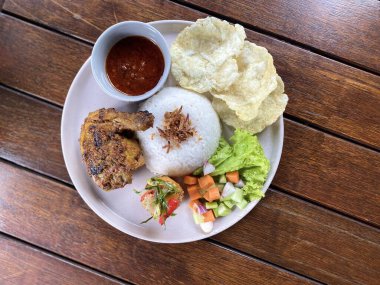 Yapışkan pirinçli kızarmış tavuk ve ahşap masada beyaz tabakta kızarmış yumurta, Tayland yemeği tarzı.