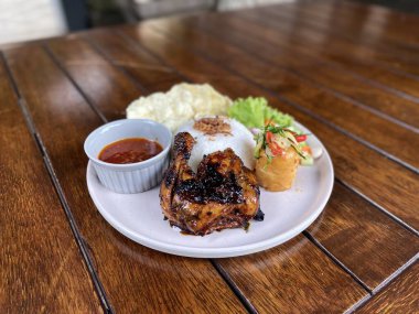 Tavuk ve ızgara pirinç ahşap masada.