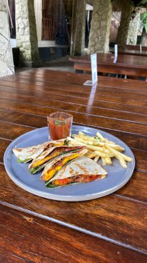 Restoran masasında ızgara et ve sebzeli Meksika yemeği.