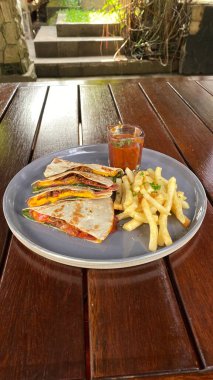 Peynirli sandviç ve tahta masada salata.