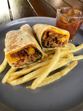 Bir tabak sığır eti, patates kızartması, domates sosu ve marul.