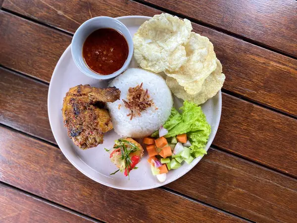Yapışkan pirinçli kızarmış tavuk ve ahşap masada beyaz tabakta kızarmış yumurta, Tayland yemeği tarzı.
