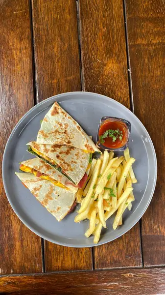 Lezzetli patates kızartması ve ahşap soslu bir tabağın yüksek açılı çekimi.