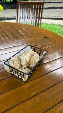 Ahşap masada kızarmış tavuk ve pilav.