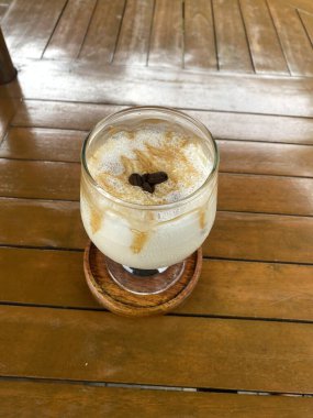 Sütlü bir fincan kahve ve beyaz bir bardak köpük.