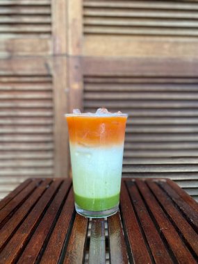 Bir bardak taze portakal suyu, saman ve buzlu.