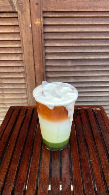 Tahta arka planda waffle fincanında dondurma.