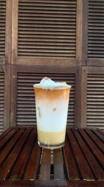 Masanın üzerinde bir bardak kahve ve buz.