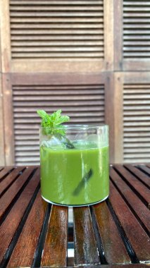 Ahşap bir masada yeşil çay ve buz