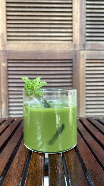 Buzlu yeşil çay ve ahşap arka planda saman.