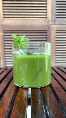 Tahta masada nane yapraklı taze yeşil smoothie.