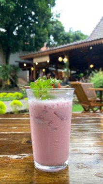 ahşap bir masa üzerinde çilek güler yüzlü