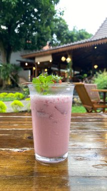 Bir bardak buzlu su ve kırmızı bir çiçek.