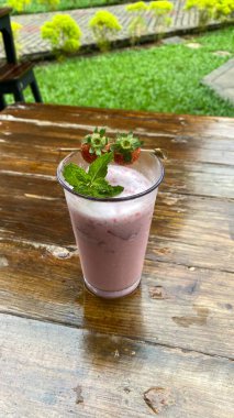 ahşap bir masa üzerinde çilek güler yüzlü