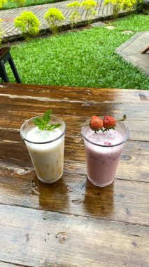 Tahta bir arka planda bir fincan çay ve dondurma.