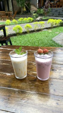 Ahşap masada buzlu çay ve krema.