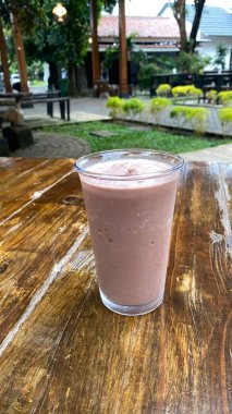 Tahta arka planda sütü olan dondurma.