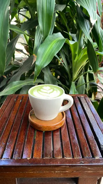 Ahşap arka planda fotokopi alanı olan yeşil kahve fincanı.