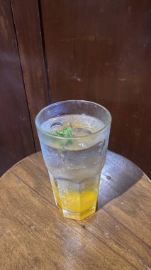 Tahta masada buzlu ve limonlu bir fincan çay.