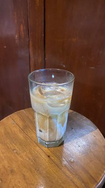 Bir bardak viski ahşap bir masa üzerinde buz ile