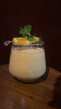 a cup of tea with lemon and ice cream on a wooden table