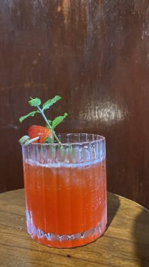 Siyah cam masada kırmızı ve beyaz naneli kokteyl.