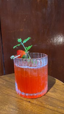 Tahta bir masada çilekli kokteyl.