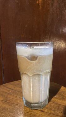 Masanın üzerinde kaşıkla bir fincan çay.