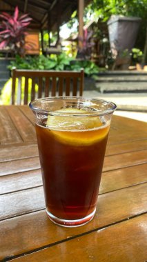 Tahta arka planda, bardakta kahve.