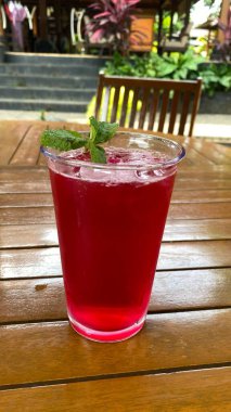 Bir bardak kırmızı şarap ve bir dilim nane ve buz.