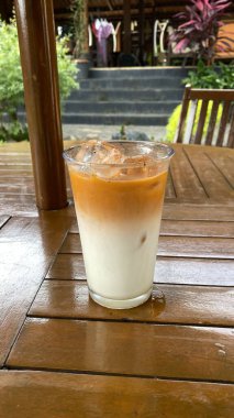 Ahşap masada buzlu kahve ve süt.