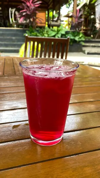 Bir bardak kırmızı şarap masanın üzerine