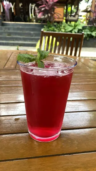 Bir bardak kırmızı şarap ve bir dilim nane ve buz.