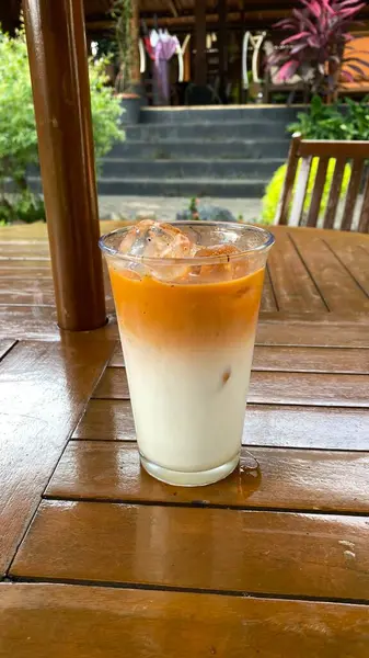 Ahşap masada buzlu kahve ve süt.