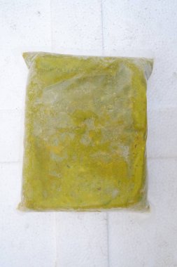 Beyaz duvarda sarı plastik çanta