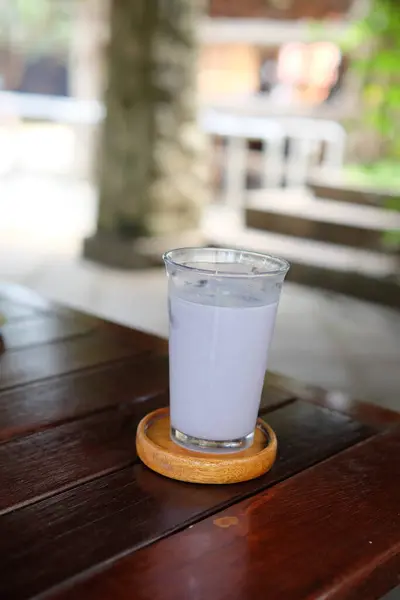 Ahşap masada bir bardak buzlu kahve.