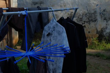 Elbiseler çamaşır ipinde asılı.