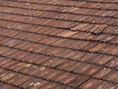 Düzensiz dokusu ve birden fazla katmanı olan eski kil kil çatı kiremitlerinin detaylı görünümü, geleneksel çatı malzemelerinin ve mimarideki işçiliğin güzelliğini ve karmaşıklığını vurguluyor.