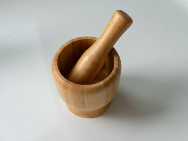 Beyaz zemin üzerinde zarif bambu havan ve tokmak, doğal ahşap dokusu ve çevre dostu tasarımı, mutfak kullanımı ve baharatlar için ideal.