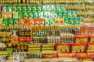 Hue, Vietnam 'daki Dong Ba Market' te canlı bir paket sergisi. Raflarda, soslar, baharatlar ve abur cuburlar da dahil olmak üzere renkli ürünlerin sıraları düzgünce düzenlenmiştir. Sahne, geleneksel Vietnam pazarının hareketli atmosferini yakalıyor..