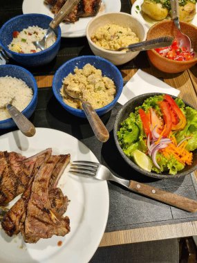 Bir Arjantin restoranında et, salata ve meze tabağı..