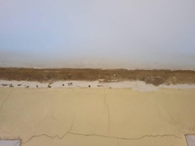 Hasarlı tavan köşesinin ayrıntıları görünür çatlaklar ve nem gösteriyor. Görüntü binanın iç duvarları ve tavanındaki yapısal bozulma ve potansiyel su hasarı sorunlarını vurguluyor.