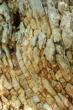 Sert, katmanlı kaya oluşumunun ayrıntılı görüntüsü eskimiş dokuları ve sıcak toprak tonlarıyla doğal jeolojik desenler sergiliyor.. 