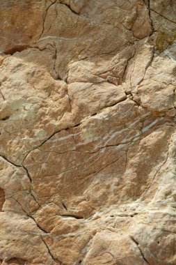 Sert, katmanlı kaya oluşumunun ayrıntılı görüntüsü eskimiş dokuları ve sıcak toprak tonlarıyla doğal jeolojik desenler sergiliyor.. 