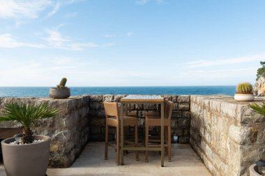 Paslı bir araba çuval ve birbirine dolanmış balık ağlarıyla dolu liman kenarında oturuyor, kıyı kasabası ve arka planda dağlar var.. 