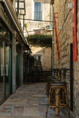 Taş duvarları, bar tabureleri ve klasik dekorlu büyüleyici bir Akdeniz ortamında açık hava koltukları olan kırsal bir sokak.. 