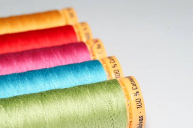 Beyaz arkaplanda renkli dikiş ipliği