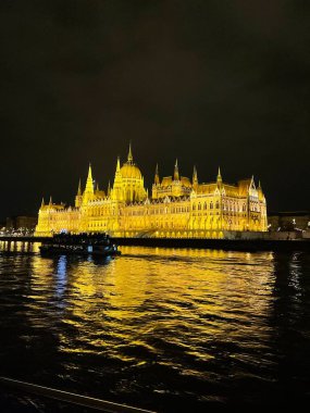 Budapeşte Parlamentosu binasının manzarası bir nehir teknesinden gece aydınlandı.